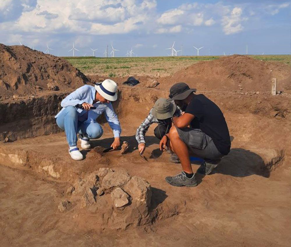 Arqueólogos examinan la tumba con el cráneo de un lobo