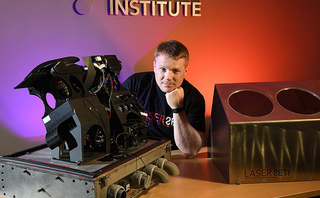 Eliott Gillum posa junto a un dispositivo del SETI Optico Eliott Gillum posa junto a un dispositivo del SETI Optico