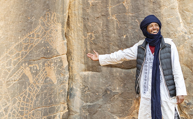 Un tuareg señalando petroglifos en Tassili