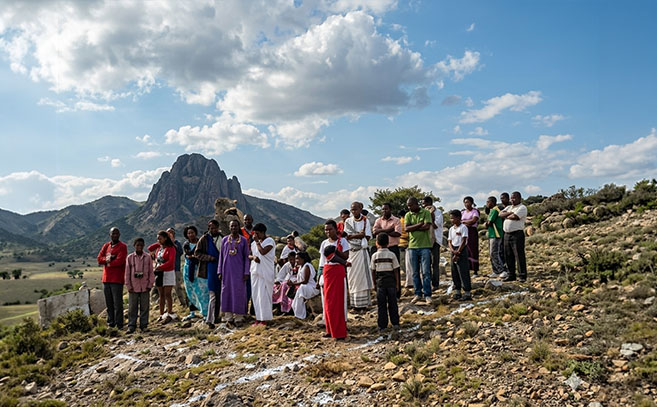 Un grupo de visitantes con la peña al fondo