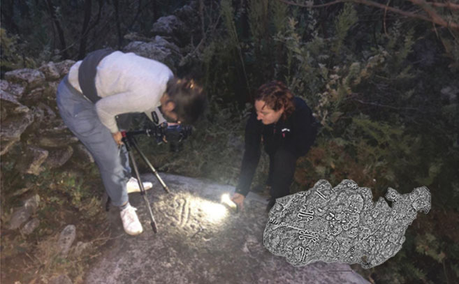 La investigfadora fotografía un petroglifo La investigfadora fotografía un petroglifo